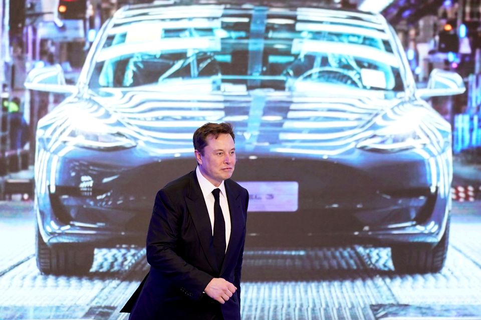 Giám đốc điều hành Tesla Inc, Elon Musk, đi bên cạnh màn hình hiển thị hình ảnh của chiếc xe Tesla Model 3 trong lễ khai mạc chương trình Model Y do Tesla Trung Quốc sản xuất ở Thượng Hải